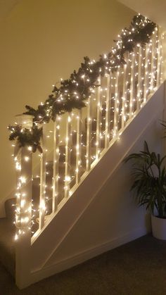 christmas garland on the bannister railing with lights and greenery at the bottom