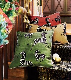 three pillows sitting next to each other on top of a wooden bench in front of a christmas tree