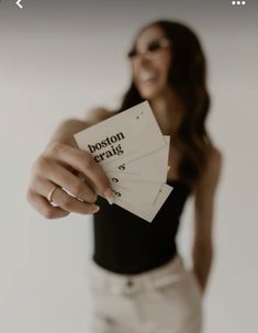 a woman holding three cards with boston gratis written on them in front of her face