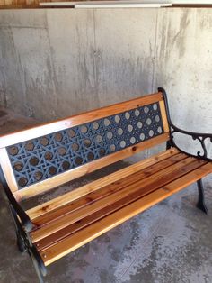 a wooden bench sitting in front of a cement wall with holes and circles on it