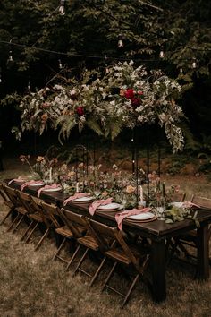 a long table set up with plates and flowers