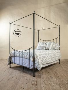 a bedroom with a four poster bed and wooden floors in the corner, along with a clock on the wall