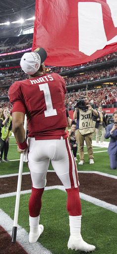 a football player holding a flag on top of a field