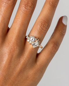 a woman's hand with a three stone ring on her left and right hand