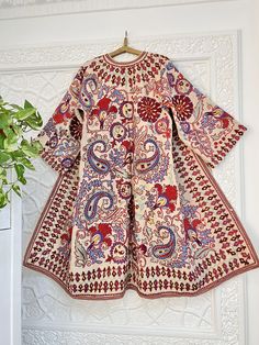 Uzbek hand embroidery suzani robe, chapan, coat. * Measurements: length - 125 cm, chest round - 120 cm, hips round - 130 cm, sleeve - 50 cm, sleeves round - 54 cm * Coat with ikat inside lining "Suzani" means needlework, but to most collectors, the word has a more specific meaning: "suzani" is synonymous with the glorious embroideries of Uzbekistan, in Central Asia. In recent years, we've witnessed a remarkable revival of this old traditional art form. These textiles are pretty complex, which indicates their importance. In fact, suzanis were part of a bride's dowry, generally started at the birth of a daughter and continued with the help of family and friends until the bride's dowry was complete and ready to be presented to the groom at the wedding. It was a symbol of the family's status, Traditional Tunic Kimono For Eid, Traditional Multicolor Kurta With Kimono Sleeves, Multicolor Embroidered Traditional Kaftan With Long Sleeves, Traditional Multicolor Kaftan With Floral Embroidery, Long Sleeve Multicolor Embroidered Kaftan With Traditional Patterns, Long Sleeve Kaftan With Multicolor Embroidery And Traditional Patterns, Multicolor Embroidered Dress With Kimono Sleeves, Multicolor Embroidered Long Sleeve Kaftan With Traditional Patterns, Traditional Tunic Kaftan With Printed Motifs