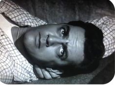 a man laying on top of a couch next to a pillow