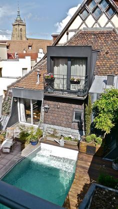 an aerial view of a house with a swimming pool in the foreground and a steeple to the right