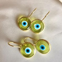 Inspired by our best-selling pendant, the breathtaking blend of colored glass and hand-painted designs in our Antique Evil Eye Earrings is bound to entice and astound. Unique in style and unmatchable in protective beauty, slip them on whenever you wish to make a strong impression, turn heads, and ignite the goddess within. 14k gold plated sterling Transparent eye .5" diameter disk Made by hand in Turkey, each piece is unique Yellow Enamel Round Jewelry, Eye-catching Gold Jewelry For Party, Hand Painted Yellow Gold Jewelry As A Gift, Hand Painted Yellow Gold Jewelry As Gift, Hand Painted Yellow Gold Jewelry For Gifts, Hand Painted Yellow Gold Jewelry Gift, Glass Dangle Jewelry, Glass Dangle Jewelry For Parties, Party Glass Dangle Jewelry