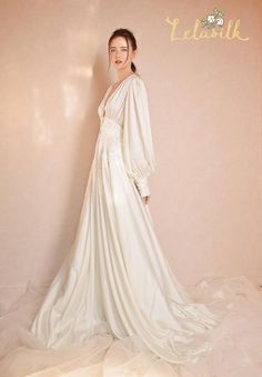 a woman in a white wedding dress standing next to a wall