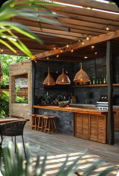 an outdoor kitchen and bar with lights hanging from the ceiling