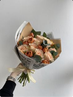 a person is holding a bouquet of flowers in their hand and it looks like they are wrapped in newspaper