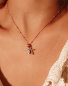 The Protégée Necklace means protected in French. This delicate charm necklace with Madonna and her cross are both iconic and beautiful, reminding you that you are protected.The Madonna pendent is gold plated silver 8x13.5mm and 2mm thick. Petite rhinestone cross features Cubic Zirconia on gold plated silver 10.5x15.5x2mm. Gold Filled chain 18 inches. Rose Gold Oval Pendant Necklace With Charms, Silver Necklace With Dangling Charms For Anniversary, Wedding Clavicle Chain Necklace With Cross Shape, Rose Gold Tarnish-resistant Cross Pendant Jewelry, Wedding Cross Necklace With Clavicle Chain, Spiritual Charm Necklaces For Wedding, Tarnish Resistant Rose Gold Cross Pendant Jewelry, Wedding Pendant Charm Necklaces, Silver Cross Pendant Charm Necklaces