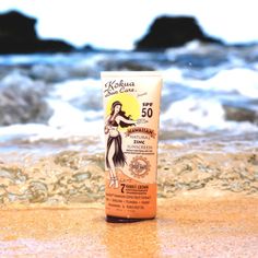 a tube of sunscreen on the beach with waves in the background