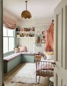 a room with a bed, window seat and bookshelf on the wall next to it