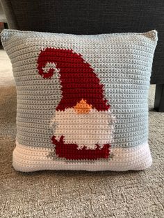 a crocheted santa clause pillow sitting on the floor