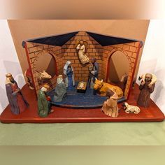 a nativity scene with figurines in front of a brick wall and doorway