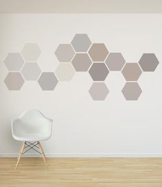 a white chair sitting in front of a wall with hexagons on it