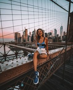 a woman sitting on top of a metal bridge