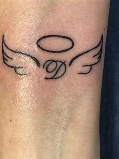 an angel tattoo on the wrist with wings and halos around it's eyes