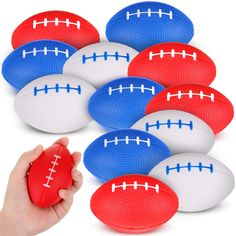 a hand is holding a red, white and blue football with six balls in it