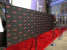 the red carpet is lined up with black and white signs