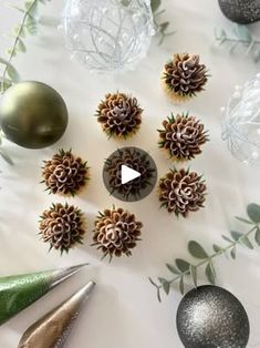 christmas ornaments are arranged on a table with scissors and other holiday decorating items in the background