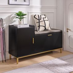 a black cabinet with a white pillow and some plants