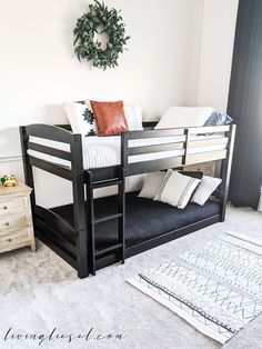 a black bunk bed with white sheets and pillows in a room next to a rug