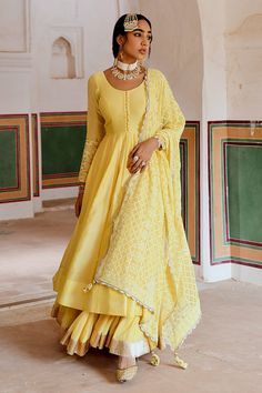 Yellow A-line flare anarkali made in chanderi base with potli buttons. Paired wit a flared skirt with a zari hemline border. Comes along with an embroidered dupatta.
Components: 3
Pattern: Placement Embroidery
Type Of Work: Zari, Thread
Neckline: Round Neck
Sleeve Type: Full Sleeves
Fabric: Anarkali: Chanderi, Skirt: Cotton Crepe, Dupatta: Embroidered Georgette
Color: Yellow
Other Details: 
Attached lining
Gota patti embroidered cuffs
Box pleated flare
Scallop laced, trellis embroidered dupatta Chanderi Anarkali, Yellow Anarkali, Cozy Sweater Dress, Traditional Attires, Indian Bride Outfits, Embroidered Anarkali, Pakistani Wedding Outfits, Simple Pakistani Dresses, Pakistani Dress Design