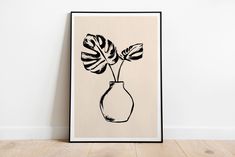 a black and white drawing of a plant in a vase on a wall next to a wooden floor