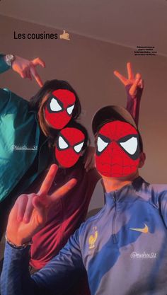 two people with their faces painted to look like they are wearing spiderman masks and pointing fingers at the camera