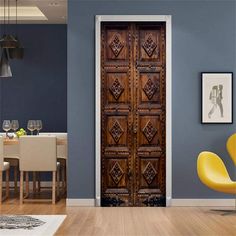 an open wooden door in a blue room with yellow chairs and pictures on the wall