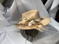 Road Warrior Custom Bridal HatFlowers can be of the color of your choosing.Available in tan or cream.4 1/2 Crown, 3 3/4 BrimCustom Color, Distressing, Band and AccessoriesAlthough each hat is unique a similar hat can be made in various sizes. Size ChartSmall - 6 7/8 Medium - 7 1/8Large - 7 3/8XL - 7 5/8XXL- 7 3/4All Sales Final Rustic Kentucky Derby Hat With Curved Brim, Rustic Curved Brim Hat For Kentucky Derby, Western Wide Brim Wedding Hat, Western Costume Hats With Curved Brim For Kentucky Derby, Rustic Brimmed Felt Hat For Kentucky Derby, Custom Wide Brim Costume Hats For Rodeo, Unique Short Brim Hat For Western-themed Events, Western Fedora Hat For Wedding, Western Style Wedding Hat With Flat Brim