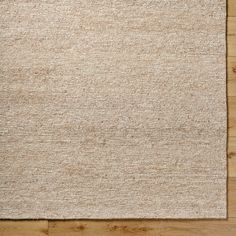 an area rug on top of a wooden floor with wood planks in the background