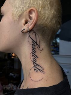 a woman with a tattoo on her neck and behind the ear that reads, believe