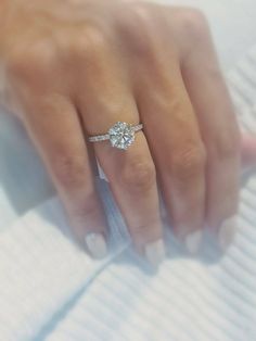 a woman's hand with a diamond ring on it