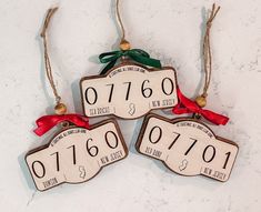 three wooden ornaments with numbers and bows on them