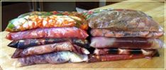 a pile of food sitting on top of a wooden table next to a plastic bag