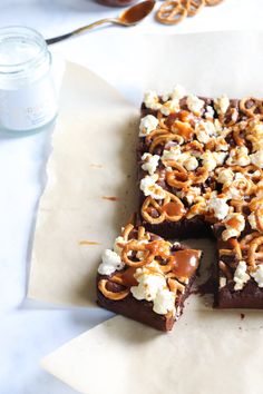 some kind of food that is on top of a piece of parchment paper next to a glass of milk