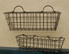 two metal baskets sitting on top of a shelf