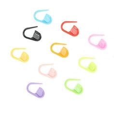 several different colored clips on a white surface