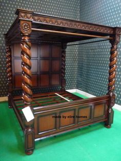 an antique wooden bed with green carpet and blue wallpaper in the background, on display