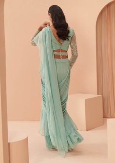 Editors Note Step into elegance with this delicate draped ruffle sari paired with an embroidered full sleeves blouse. This ensemble combines timeless charm with modern sophistication, making it a perfect choice for special occasions where you want to make a lasting impression.