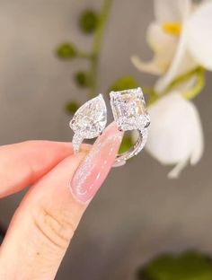 a woman's hand holding two engagement rings