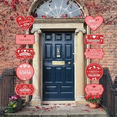 a blue door with lots of valentine's day signs hanging from the side of it