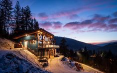 a house on the side of a mountain at night with lights on it's windows