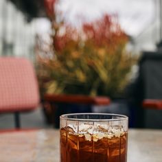 a glass filled with ice sitting on top of a table