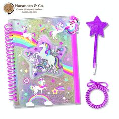 an open notebook with unicorns and stars on the cover next to a purple pen