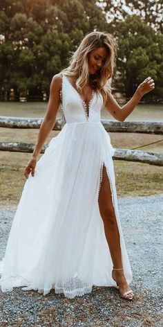 a woman in a white dress is posing for the camera with her legs spread out