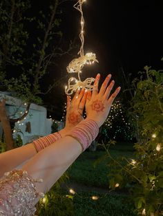 a woman's hand with hendix on it reaching up into the air